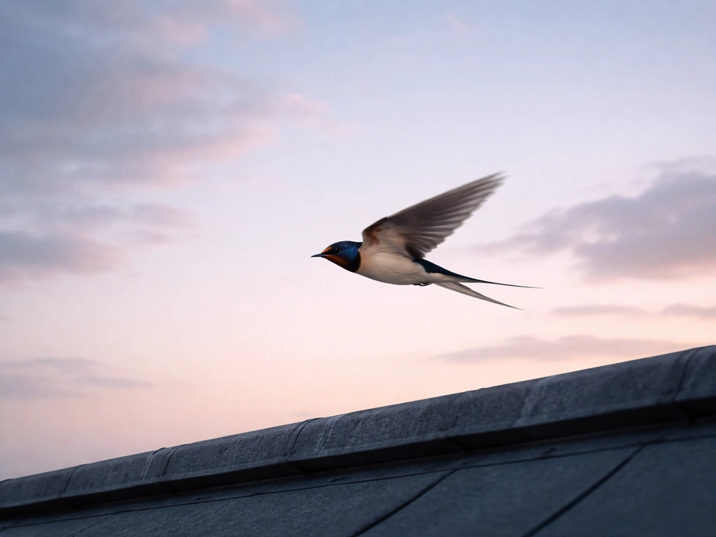 A swallow darts and hovers above a rooftop edge against a soft dusk sky.