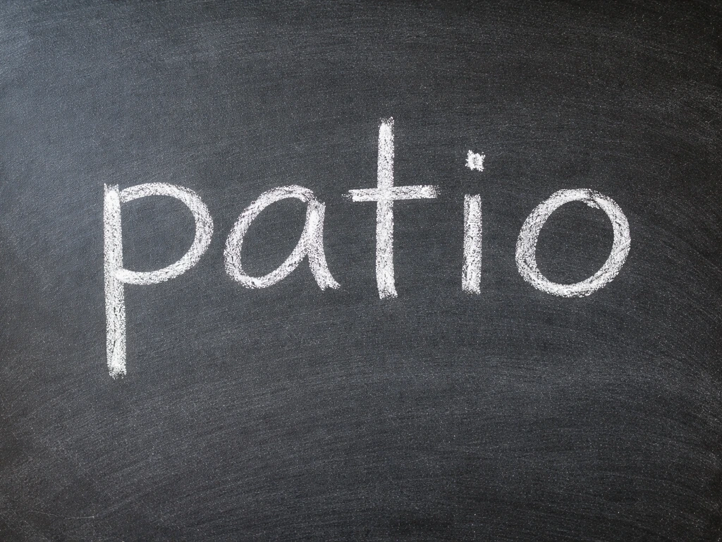 Close-up of the word patio written clearly in chalk on a simple surface