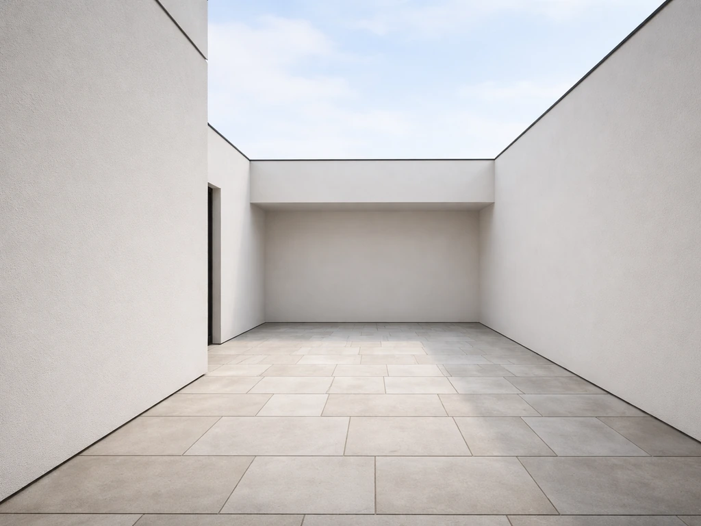 Minimal view of a patio by a house wall and an adjacent more enclosed courtyard area
