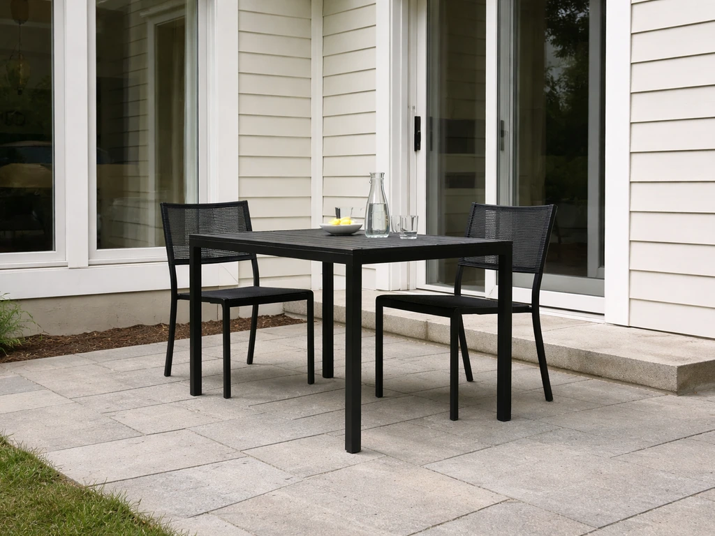 Flat paved patio beside a home with outdoor dining set under soft daylight.