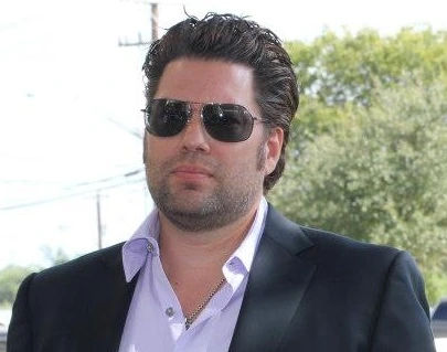 Armando Montelongo Jr. at an Armando Montelongo Companies grand opening and ribbon cutting event, wearing sunglasses and