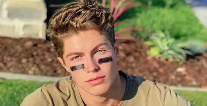Ben Azelart posing outdoors with a casual expression, wearing eye black, in a landscape-oriented photo.