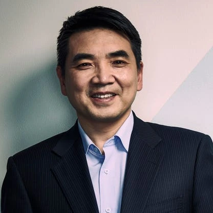 Eric Yuan in a portrait photo, wearing a dark blazer and light blue shirt.