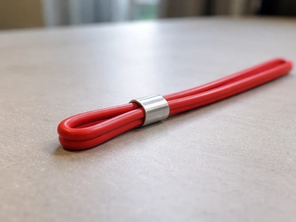 Excess metal wire folded back and aligned with a ferrule crimp sleeve ready for clamping.