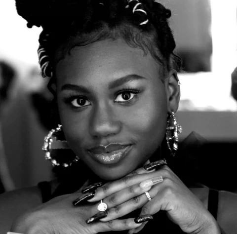 Zandra Azariah Cunningham in a black-and-white portrait with her hands under her chin.