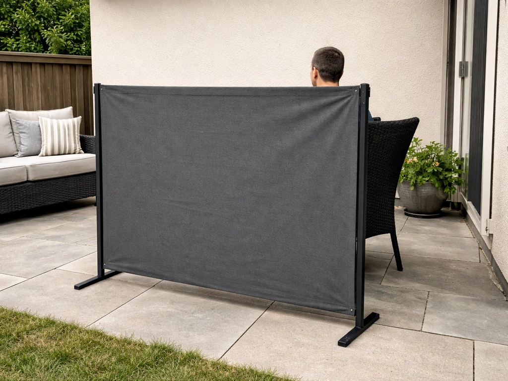 6-foot windbreak fence on a patio with a seated adult partially visible above it for height scale.