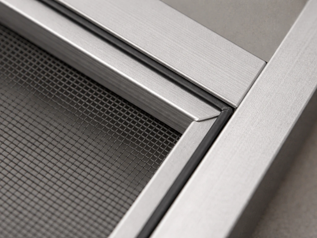 Close-up of a window screen corner showing rubber spline fully seated at the junction.