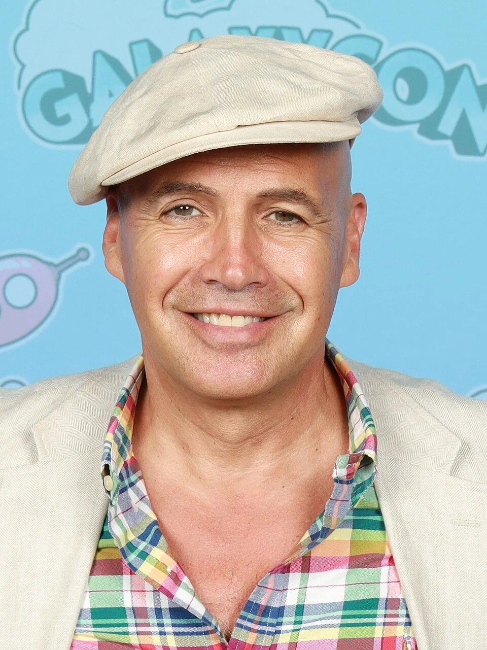Billy Zane smiling at an event in front of a blue GalaxyCon backdrop.