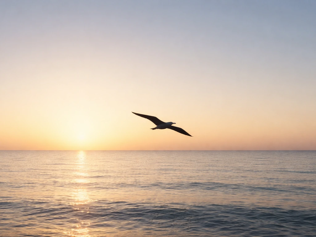 Silhouette of an albatross gliding over a calm ocean horizon at sunrise.