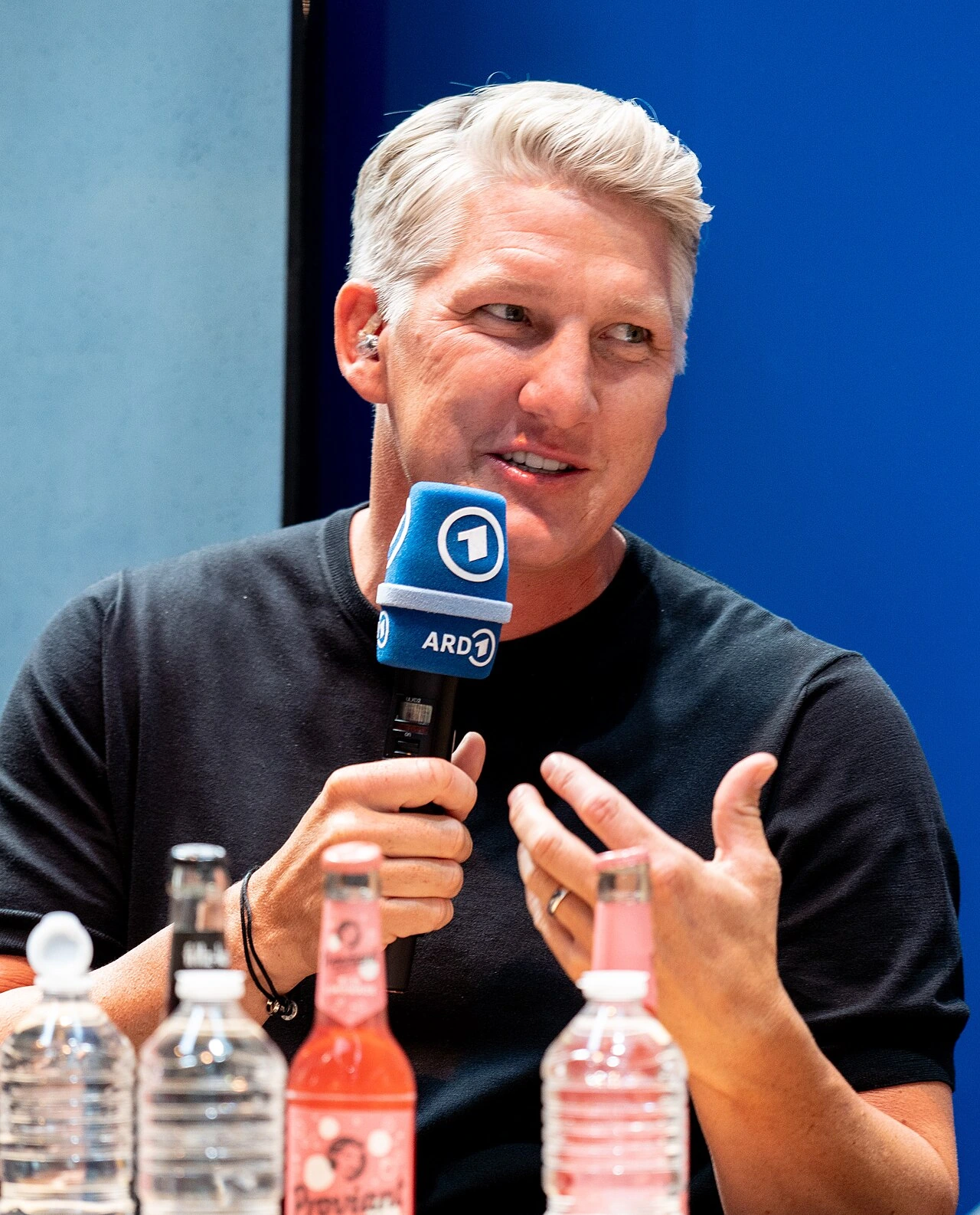 Bastian Schweinsteiger speaking into a microphone at an event