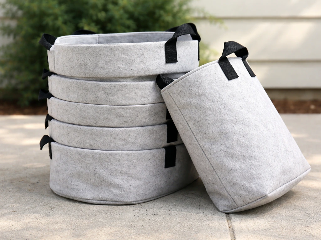 Stack of freshly cleaned, bright fabric grow bags, soil-free and fully dried, ready to reuse for planting