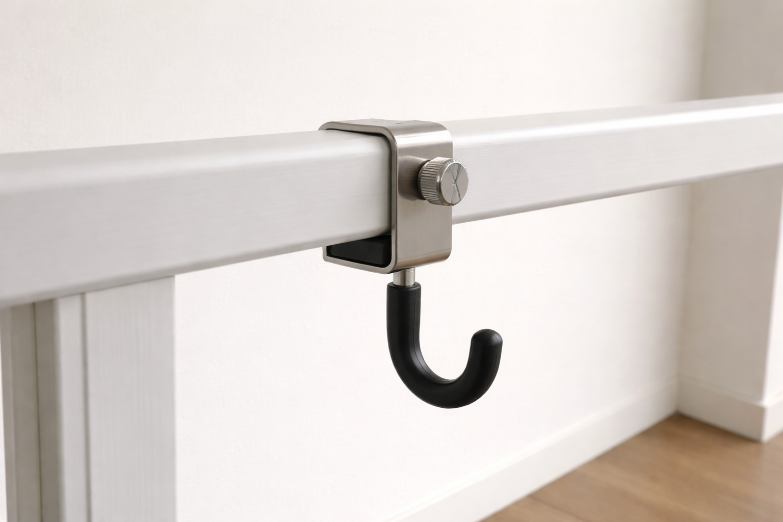 Close-up of a rubber-padded clamp-on hook attached to a balcony rail.