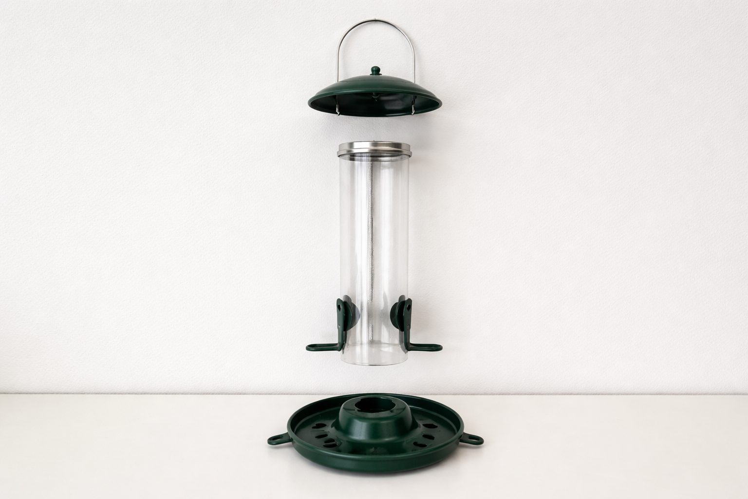 Disassembled feeder parts laid out for cleaning on a plain surface.