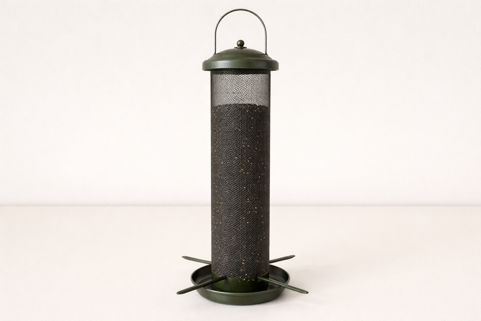 A finch-style nyjer mesh feeder filled with nyjer seed.