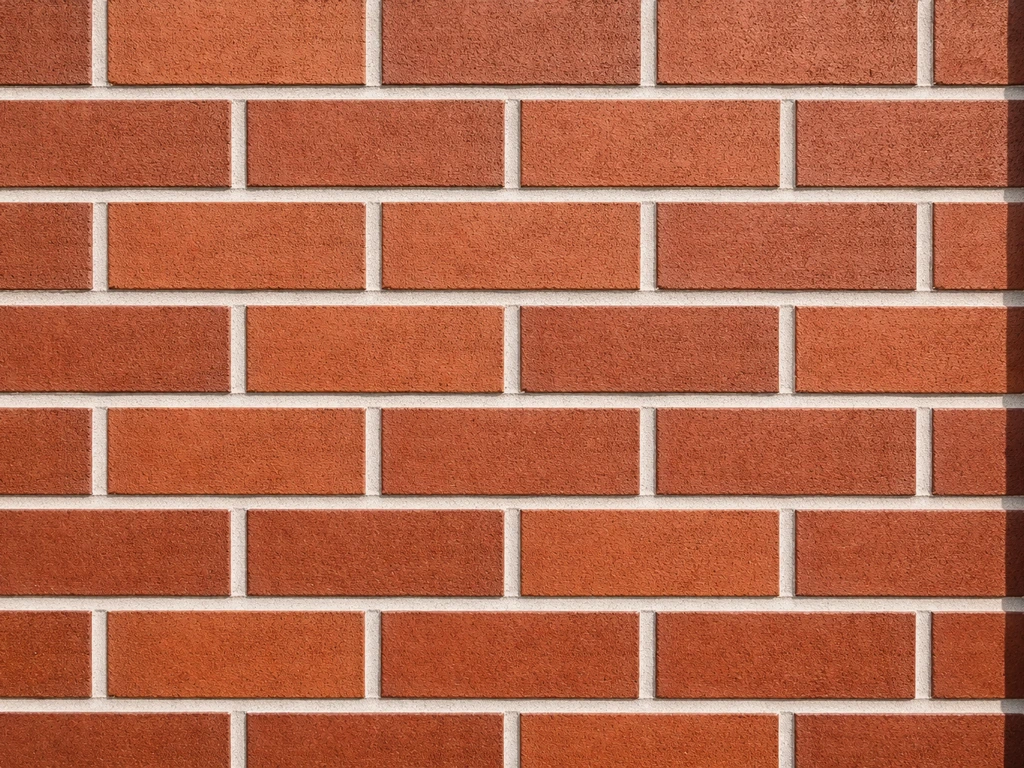 Close-up of a brick wall in perfect stack bond grid, showing sharp alignment and precise cut edges.