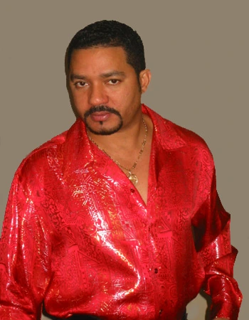 Portrait photo of bachata musician Frank Reyes wearing a red shirt