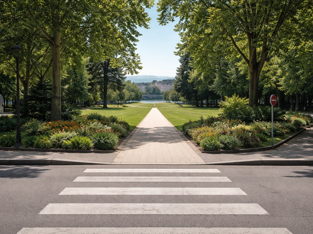 Allée piétonne menant à la pelouse du Parc Jouvet, entrée du parc sur fond de verdure et bâtiments près du Rhône.