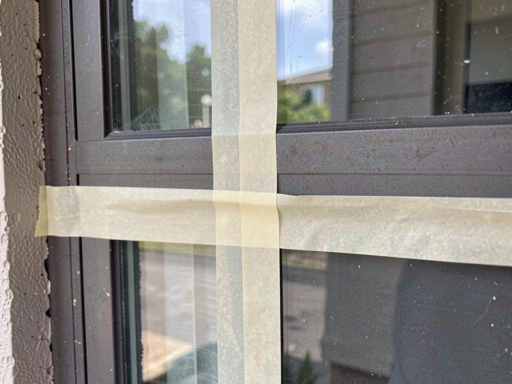 Grid of painter’s tape strips spaced on the outside of a window to break up reflections