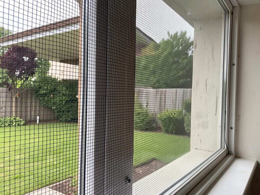 Window netting stretched a few inches away from glass creating a buffer zone