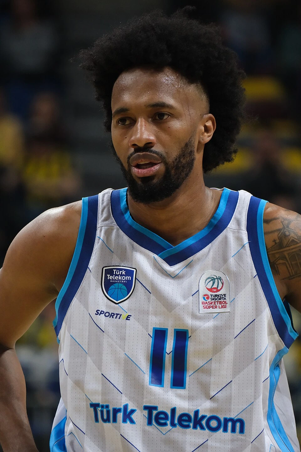 Braian Angola in action during a basketball game, wearing a Türk Telekom jersey.