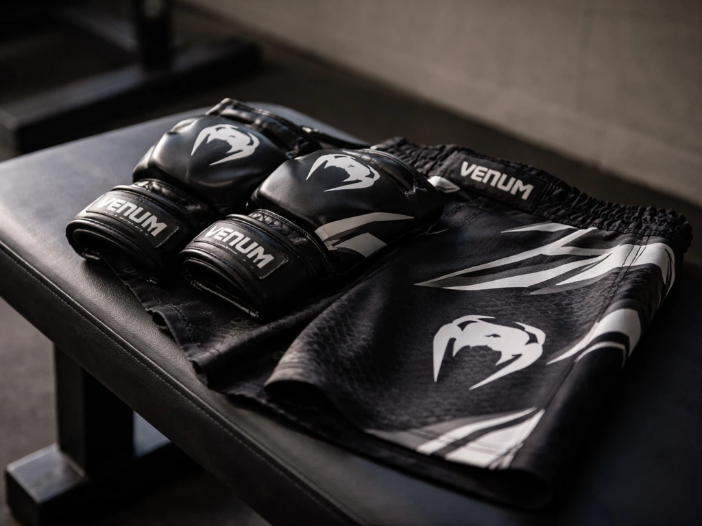 Close-up of official Venum-branded UFC fight gear on a gym bench, highlighting sponsorship apparel details.