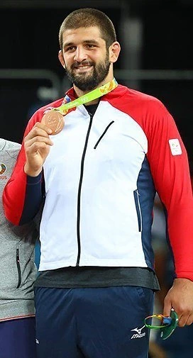 Geno Petriashvili posing with a medal at a wrestling event