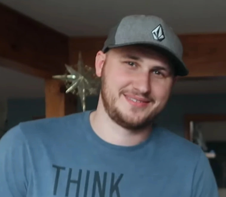 Taras Vladimirovich Kulakov, known as CrazyRussianHacker, smiling in a cap and blue T-shirt