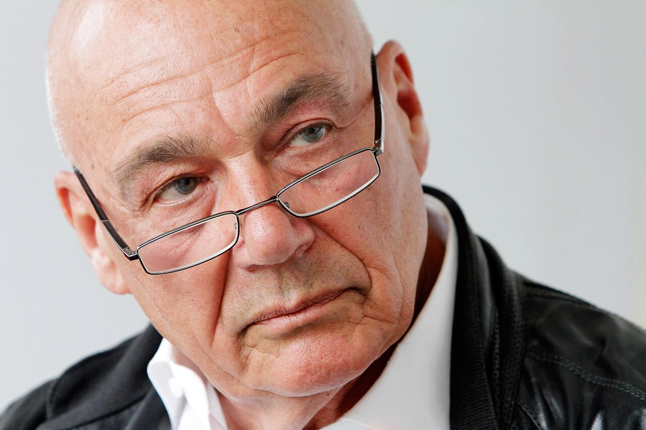Portrait photo of Vladimir Pozner wearing glasses, looking to the side.