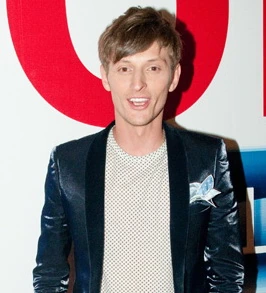 Pavel Volya posing at an event, wearing a dark jacket over a light shirt.