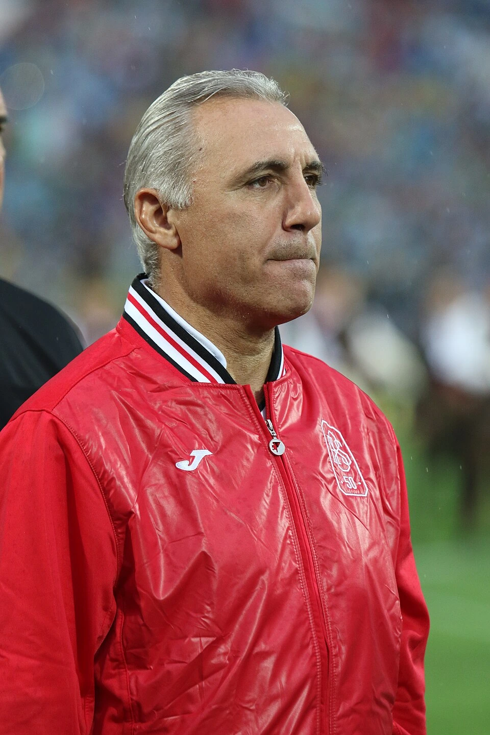 Hristo Stoichkov in a red jacket at a football match