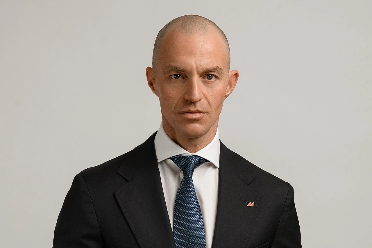 Portrait photo of Alexander Vinokurov in a suit and tie against a neutral background