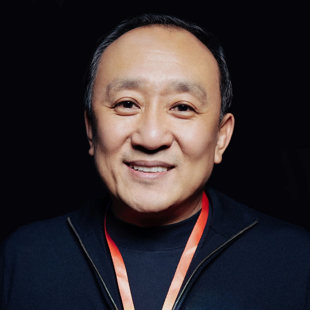 Portrait of Vyacheslav Kim smiling against a dark background.