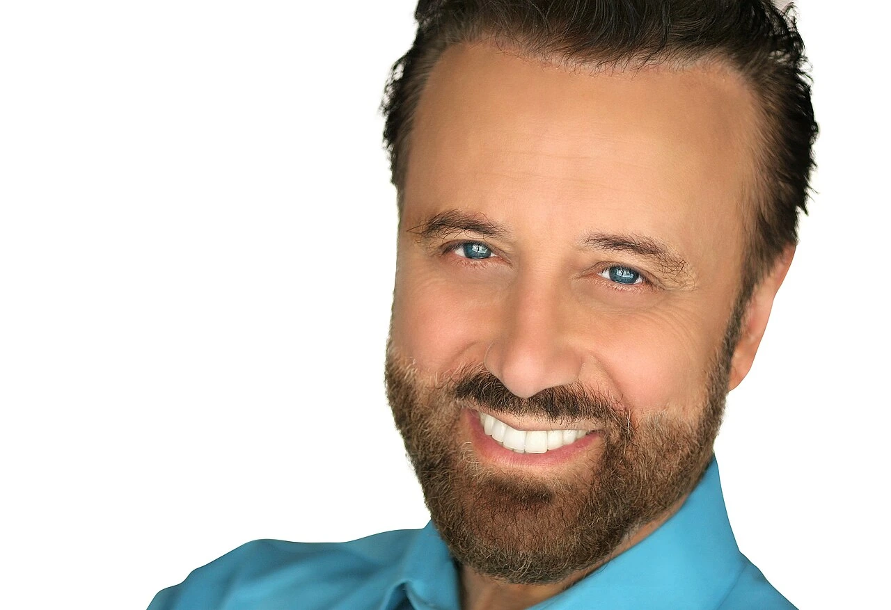 Yakov Smirnoff posing for a headshot against a white background