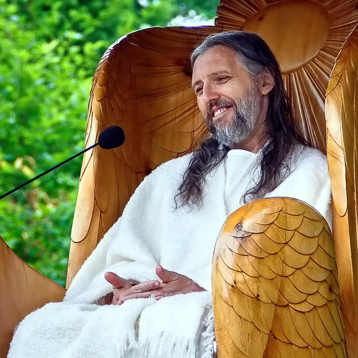 Sergei Torop, also known as Vissarion, smiling outdoors in a white robe at a public event.