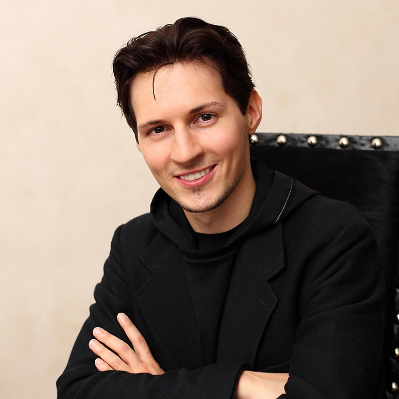 Pavel Durov smiling in a black outfit at an event