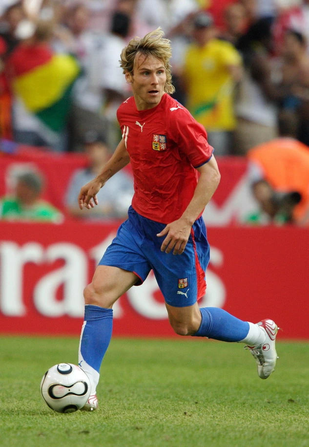 Pavel Nedvěd in a Czech Republic football match, running with the ball in a red jersey and blue shorts.