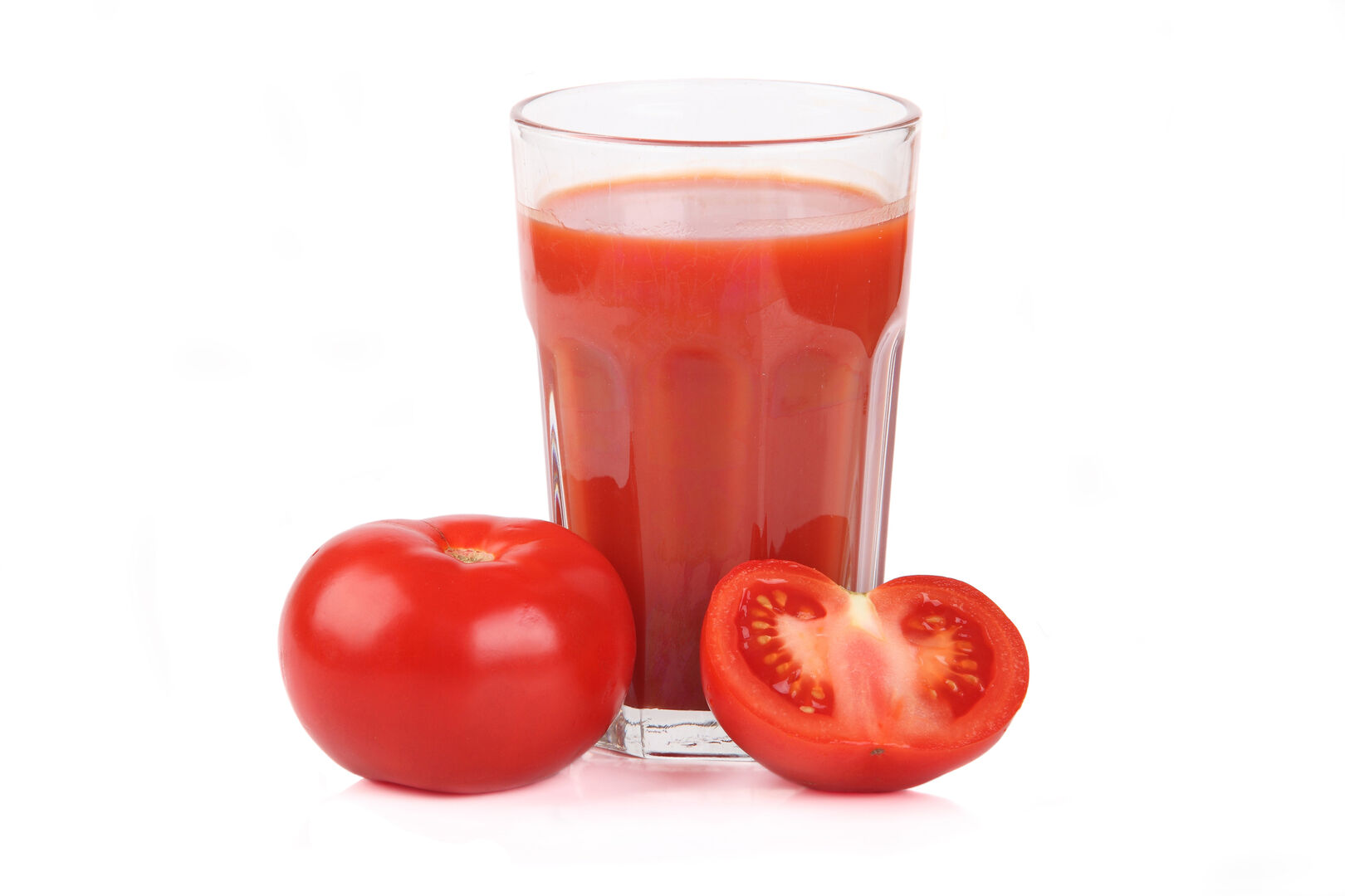Ein Glas Tomatensaft und aufgeschnittene Tomaten.