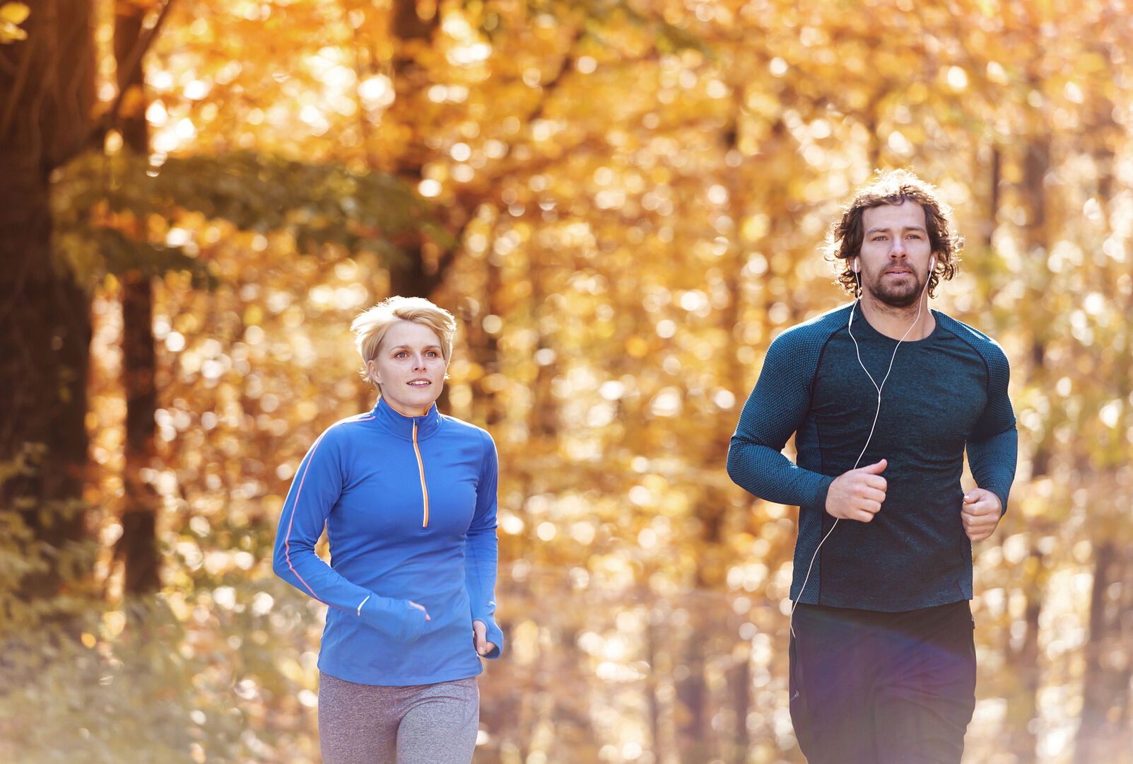 Paar joggt durch herbstlichen Wald