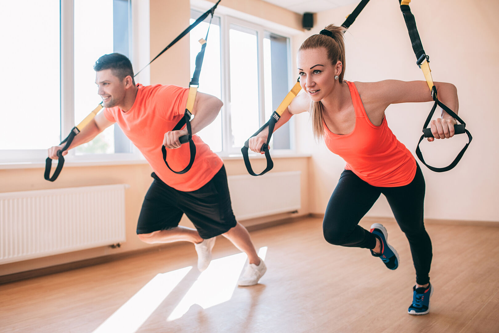 Mann und Frau bei TRX-Training in Wohnung
