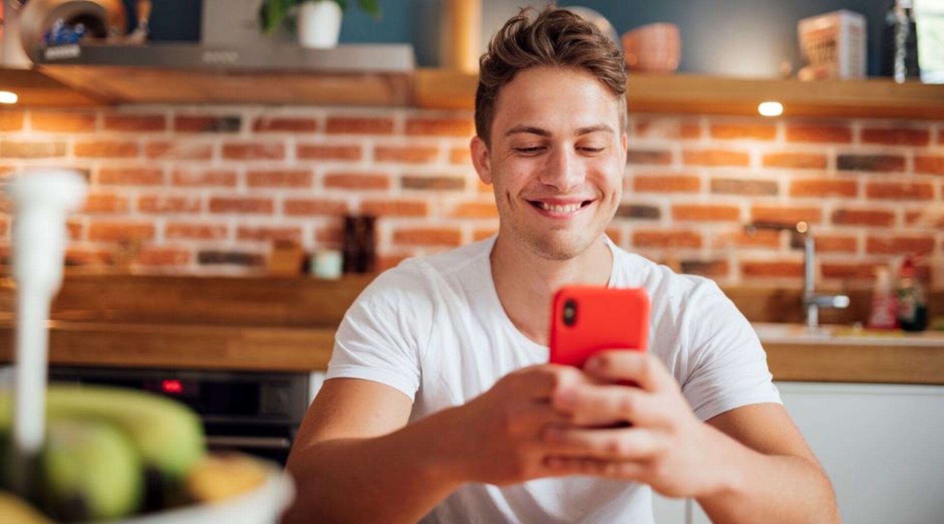 Junger Mann lacht über Smartphone-Witz | Credit: iStock.com/Pascal Skwara