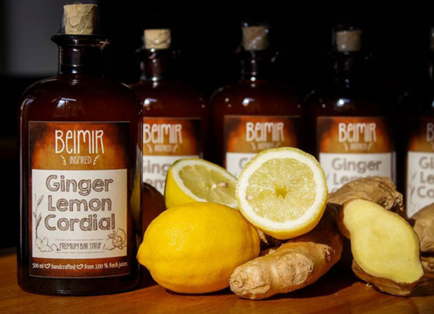 Eine Flasche mit dem Etikett &quot;Ginger Lemon Cordial&quot;, Zitronen und Ingwer