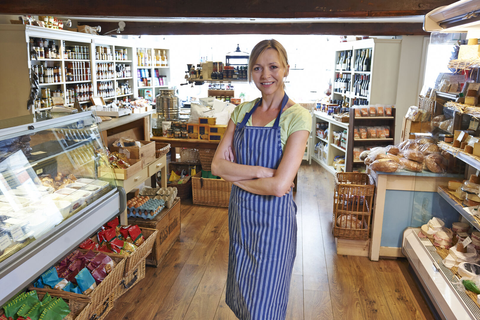 Verkäuferin in gut sortiertem Feinkostladen