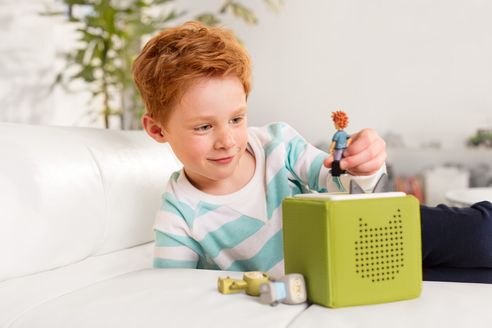 Ein Kind setzt eine Figur auf eine Toniebox