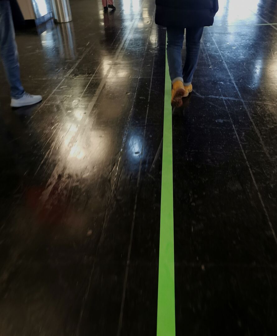 Eine grüne Linie am Boden zeigt den Weg zum Ausgang.