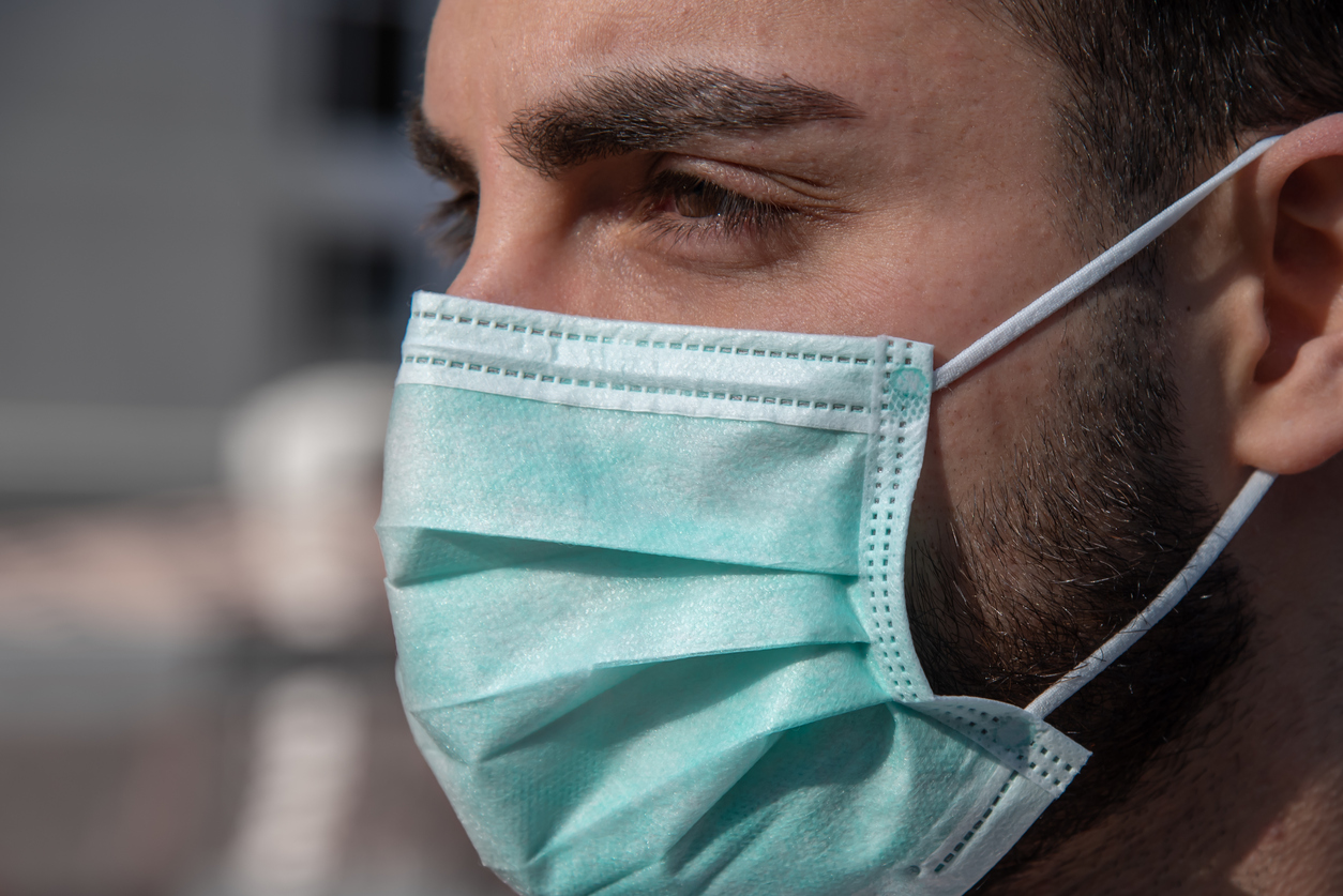 Porträt eines jungen Mannes mit Bart und OP-Maske