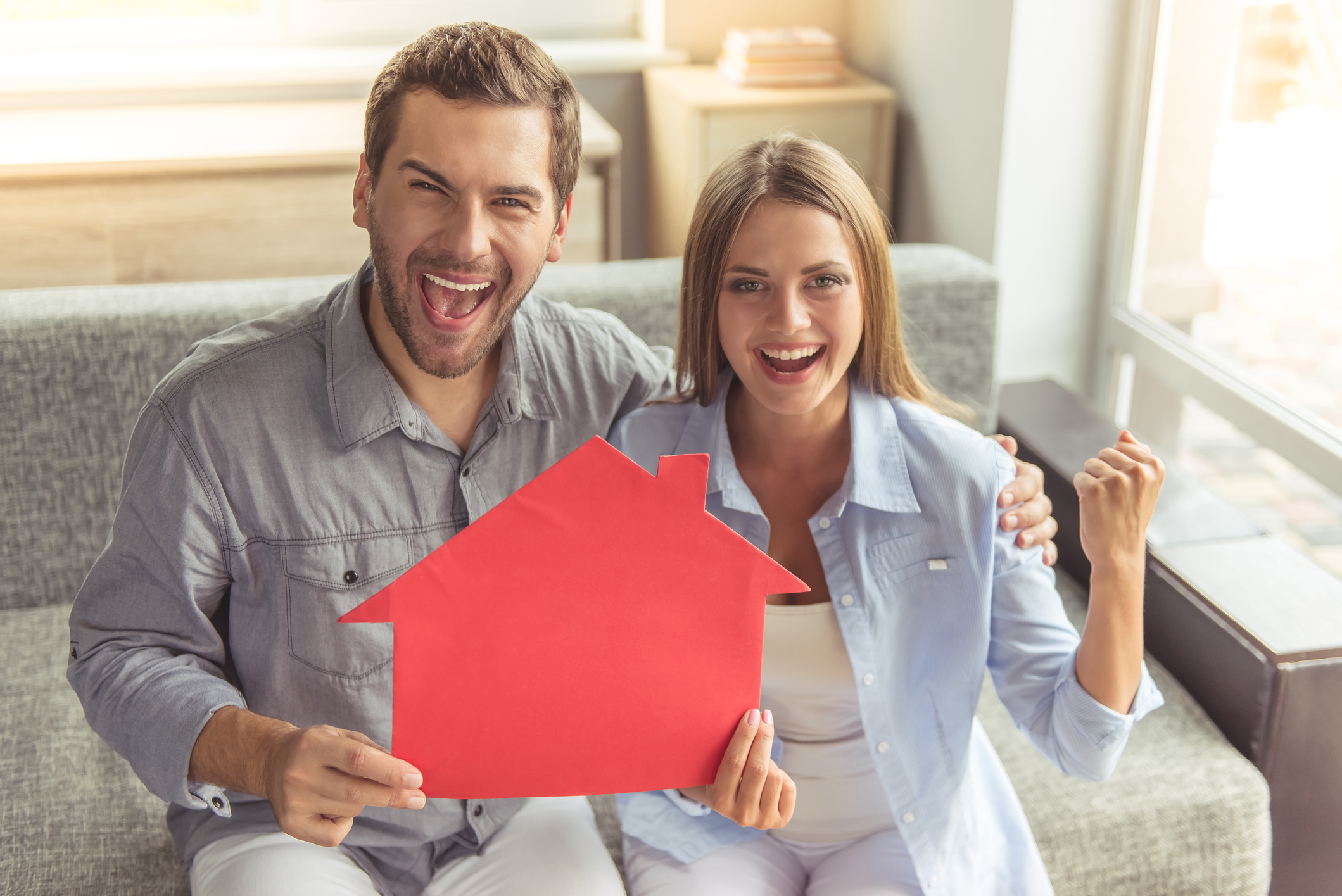 Pärchen hält den Traum vom Eigenheim in Händen