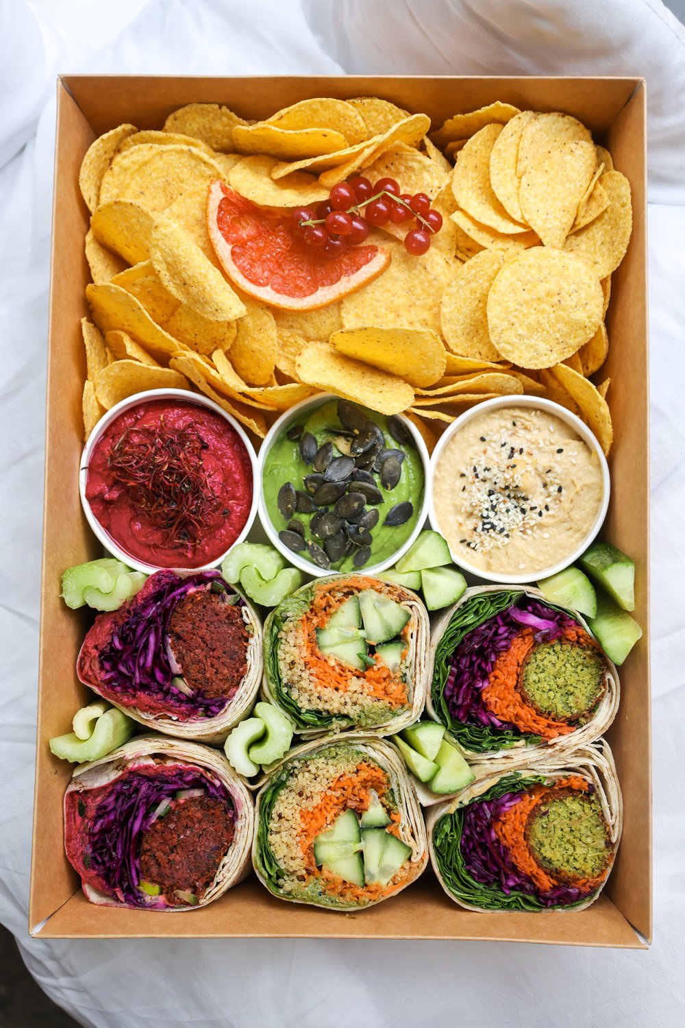 Ein Karton mit Wraps und Chips von oben fotografiert