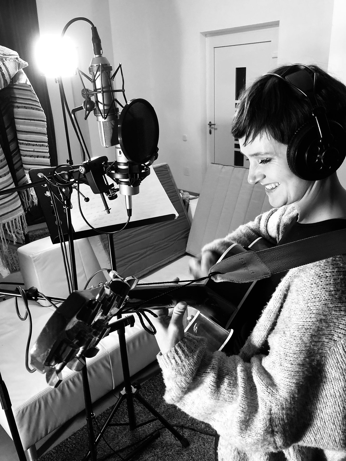 Eine Frau steht mit ihrer Gitarre in einem Aufnahmestudio