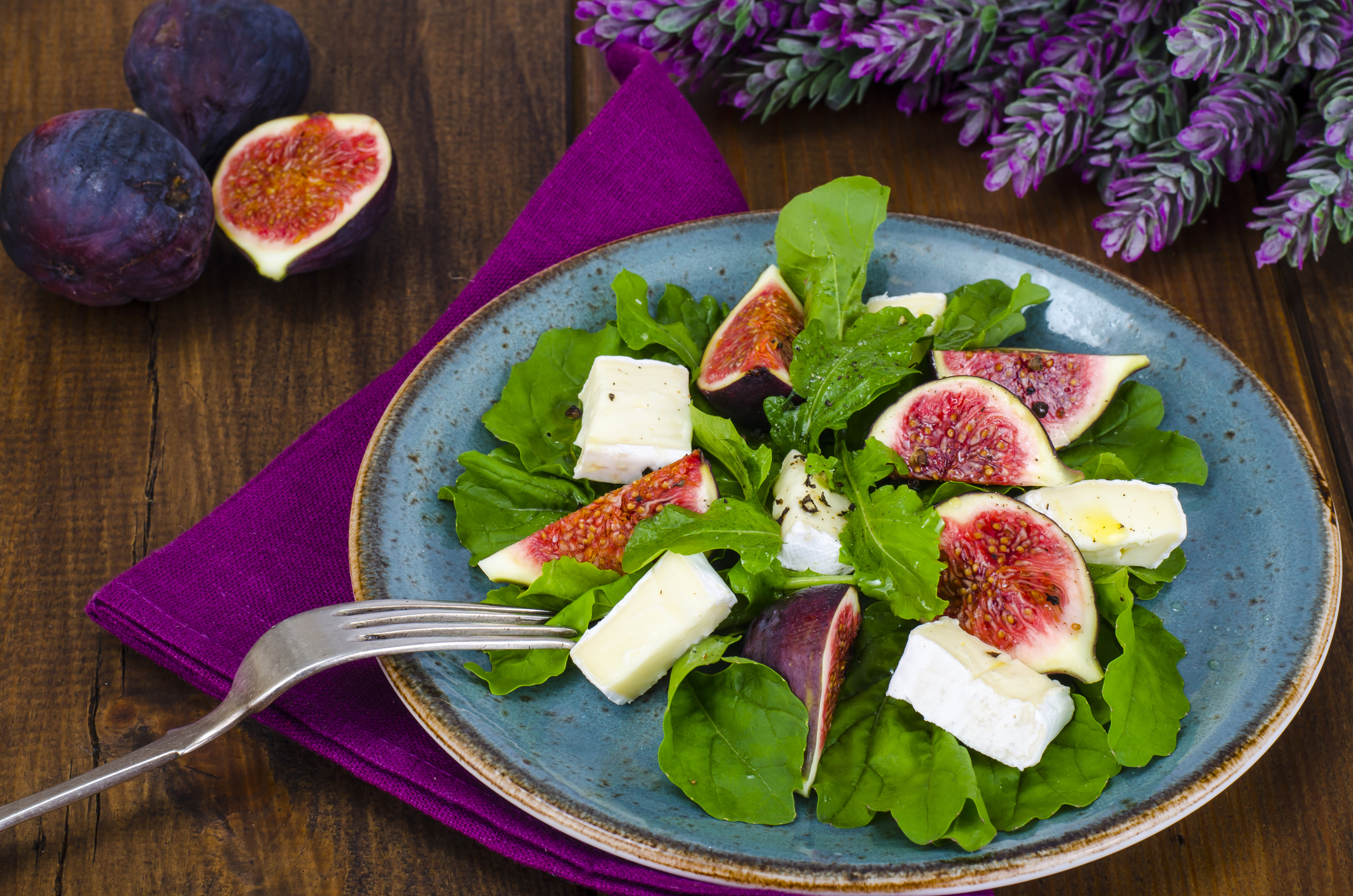 Ein Salatteller mit Mozzarella und Feigen auf einem Esstisch