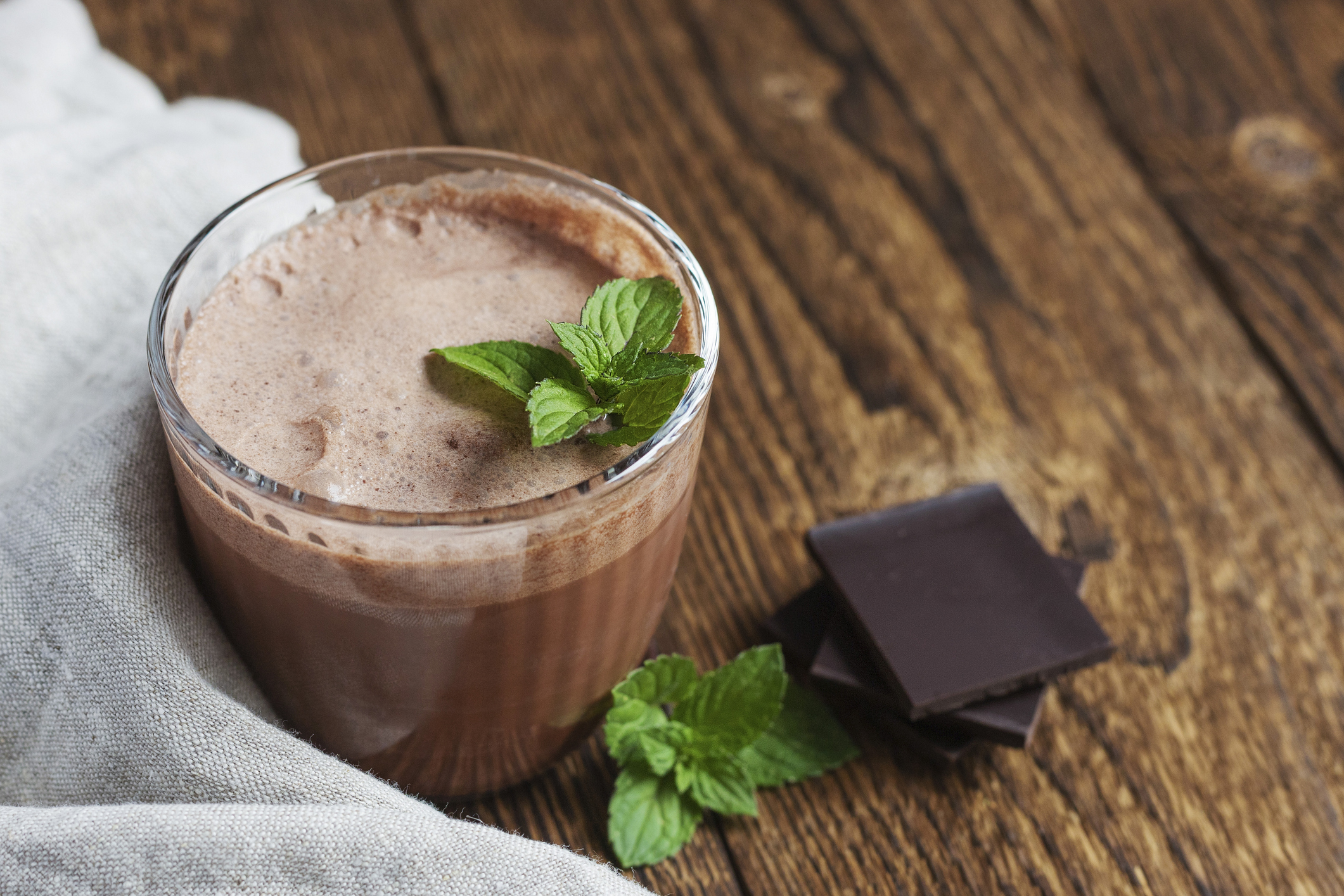 Ein Glas mit einem Getränk aus Minzschokolade auf einem Holztisch.